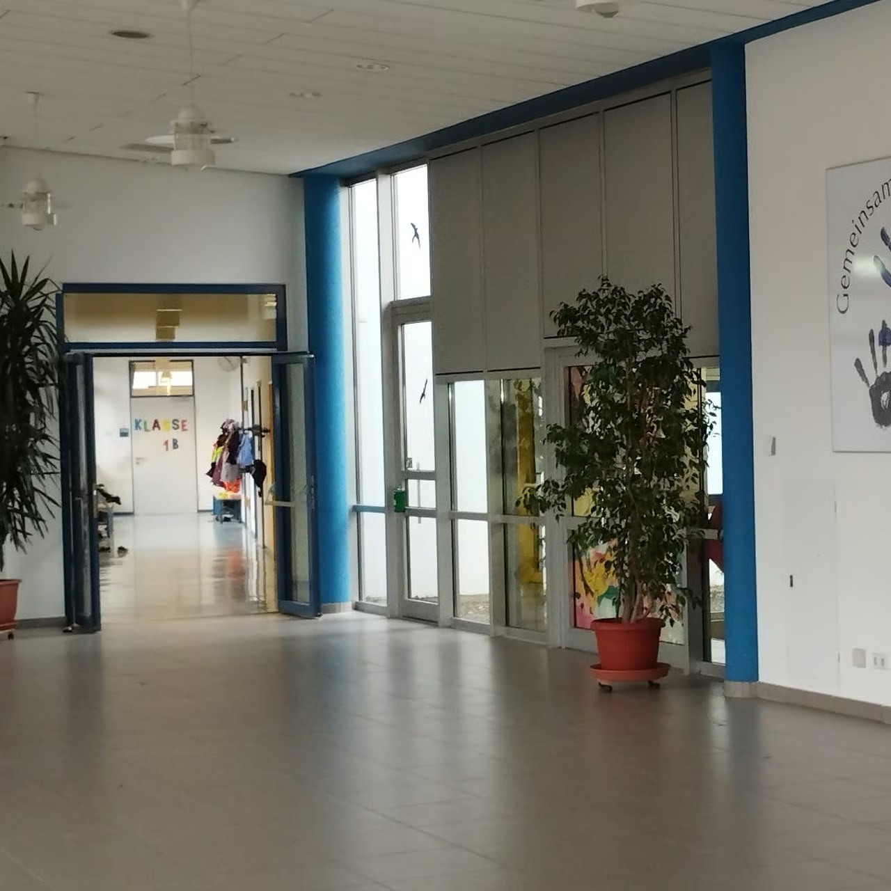Lichtdurchflutetes Foyer mit Eingangstüren und Pflanzen